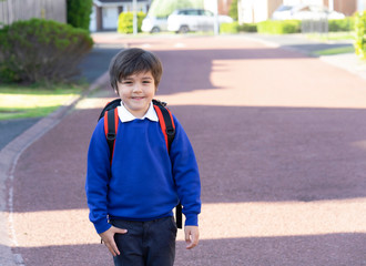 Outdoor portrait of happy child boy with backpack, School kid waiting for school bus, Pupil of primary going to school,Young student beginning of class after school holiday,Back to school concept