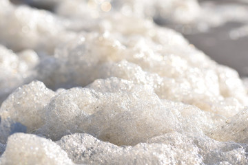 Naklejka na ściany i meble Detail of foam washed up onto a beach