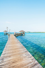 Empty wooden bridge extending into the blue sea.