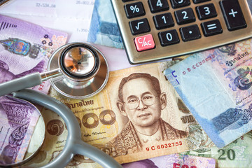 stethoscope on Thai baht  banknote background ,concept of healthcare budget and insurance 