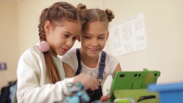 Nice, smiling and smart girls are engineering the robot on the robotics class slow motion
