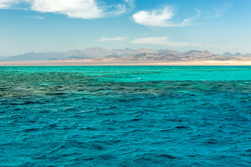 Fototapeta premium Seascape, view of the blue sea with high bald mountains in the background