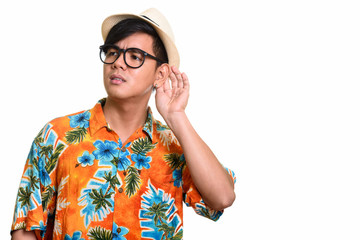 Studio shot of handsome Asian man listening