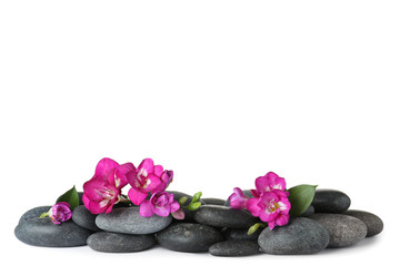 Obraz na płótnie Canvas Pile of spa stones and freesia flowers on white background