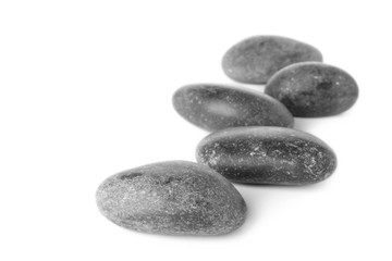 Many grey spa stones on white background