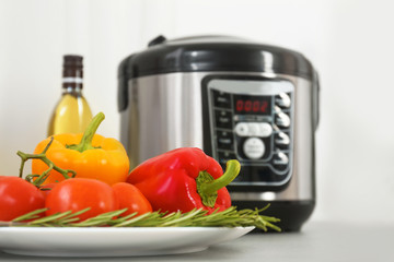 Modern multi cooker and products on kitchen table