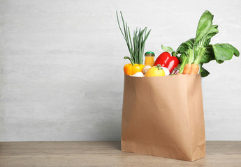 Paper bag with vegetables and bottle of juice on table against grey background. Space for text - Powered by Adobe