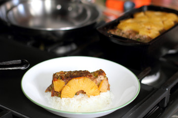 Plate of Hawaiian style meatloaf with rice on the stove.