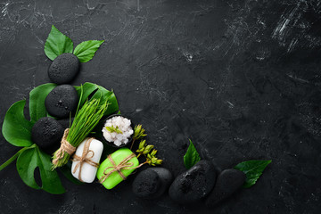 Zen stones and leaves with water drops. Spa background with spa accessories on a dark background....
