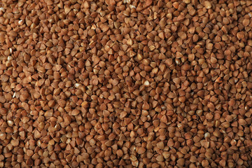 Uncooked buckwheat as background, top view. Organic wholesome product