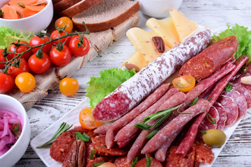 Smoked sausages assortment on the white tray. Meat plate