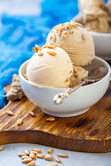 Ice cream with seeds and halva in a white bowl.