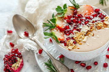 Healthy smoothie bowl of strawberries, pomegranate and almonds.