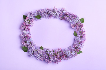 Frame made of blossoming lilac flowers on color background, flat lay. Space for text