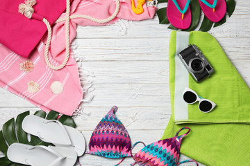 Obraz premium Flat lay composition with swimsuit and beach accessories on wooden background. Space for text