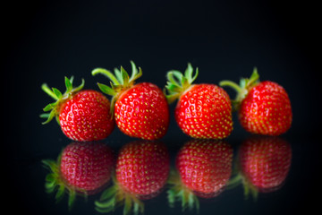 ripe red strawberries on a black background