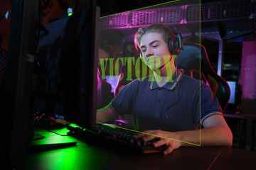 Professional young caucasian gamer playing online on his PC. He upset because of losing the game