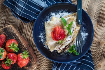 Polish pancakes with jam, cheese and strawberries.