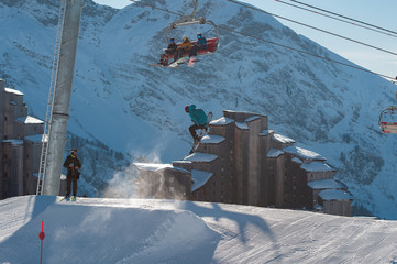 A snowboarder hitting his jump off the kicker in the snowpark
