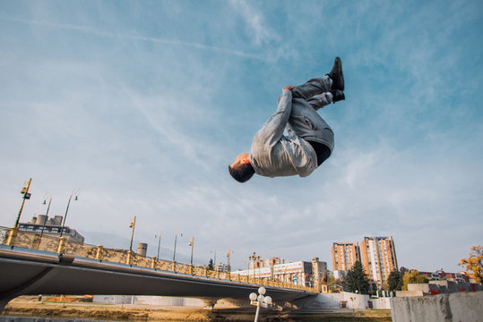 Sportive man make parkour tricks while jumping
