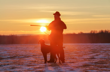 A hunter in the hat with a gun and his German Shorthaired Pointer dog breed friend. Beautiful...