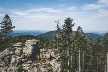View from the top of a mountain into the valley with clouds in the blue sky and beautiful green...