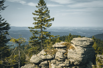 View from the top of a mountain into the valley with clouds in the blue sky and beautiful green...