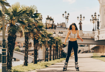Happy joyful young woman wearing roller skates in town