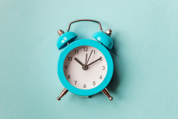 Ringing twin bell vintage classic alarm clock Isolated on blue pastel colorful trendy background....