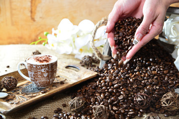 Cappuccino Hand mit fallenden Bohnen