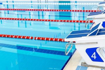 Swimming pool with marked red and white lanes. Empty swimming pool without people with quiet standing water. Water sports in indoor pool.