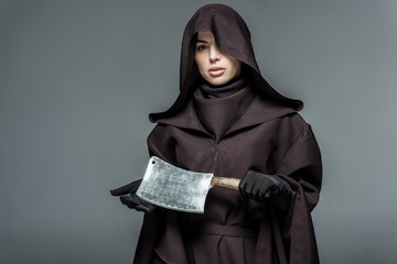 woman in death costume holding cleaver isolated on grey