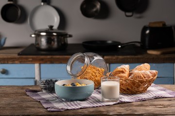 Delicious breakfast. Sweet cornflakes with honey. Fresh croissant with milk. Healthy food. Kitchen
