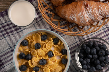 Croissant and corn flakes - delicious dessert. Breakfast. Fresh berry and milk. Morning meal.