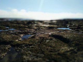 Volcanic shore rock under blue sky