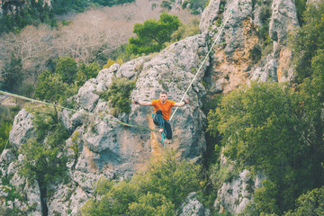 A man sits on a stretched sling.