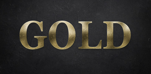 Schriftzug "GOLD" vor dunklem Papierhintergrund
