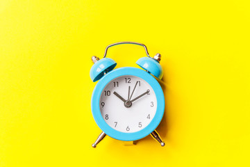 Ringing twin bell vintage classic alarm clock Isolated on yellow colourful trendy modern...