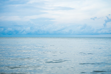 Fototapeta na wymiar Landscape horizontal skyline of ocean and calm sea with clouded sky in background