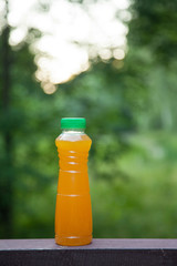 delicious citrus juice in a plastic bottle on the background of summer nature