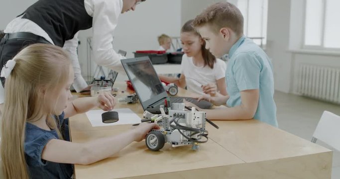 Curious kids working on a functional programable robot during robotics class at school. 4K UHD 60 FPS SLOW MOTION