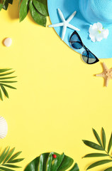 Tropical Background. Palm Trees Branches with starfish and seashell on yellow background. Travel. Copy space.