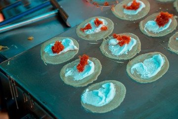 Cooking Fresh Thai Crispy Pancake. Thai Crispy Pancake Sweet that the trader is selling in the market Is a delicious dessert with crispy flour And filled with coconut cream.