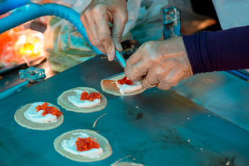Cooking Fresh Thai Crispy Pancake. Thai Crispy Pancake Sweet that the trader is selling in the market Is a delicious dessert with crispy flour And filled with coconut cream.