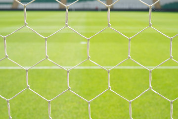Fototapeta premium Close up detail of a soccer net against green grass
