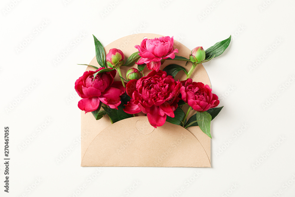 Wall mural Beautiful peony flowers in envelope on white background, space for text