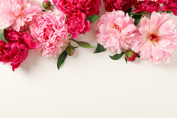 Obraz na płótnie Canvas Flat lay composition with beautiful peonies on white background, space for text and top view