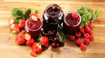 assortment of jams, seasonal berries, cherry, mint and fruits in glass jar