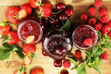 assortment of jams, seasonal berries, cherry, mint and fruits in glass jar