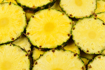 Pineapple juicy yellow slices background. Top view.